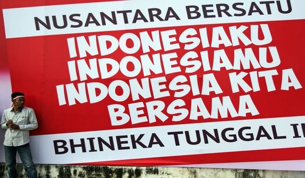 Seorang warga beridiri di depan spanduk Nusantara Bersatu ketika mengikuti rangkaian acara Nusantara Bersatu di Pekanbaru, Riau, Rabu (30/11). Kegiatan Nusantara Bersatu itu dilakukan guna mengingatkan kembali kepada seluruh lapisan masyarakat agar tidak m