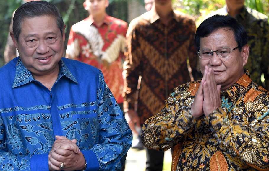 Ketua Umum Partai Gerindra Prabowo Subianto (kanan) dan Ketua Umum Partai Demokrat Susilo Bambang Yudhoyono (kiri) memberikan salam kepada media sebelum melakukan pertemuan tertutup di kediaman Prabowo, Jalan Kertanegara, Jakarta Selatan, Senin (30/7).