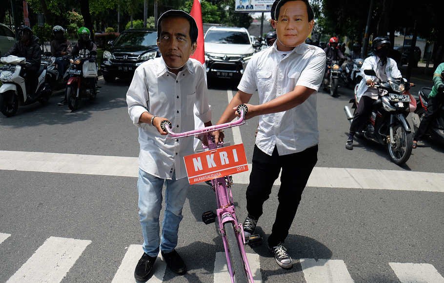 Anggota Komunitas Kuliner Binjai memakai topeng bergambar Bakal Calon Presiden Joko Widodo dan Prabowo Subianto di Medan, Sumatera Utara, Kamis (13/9).