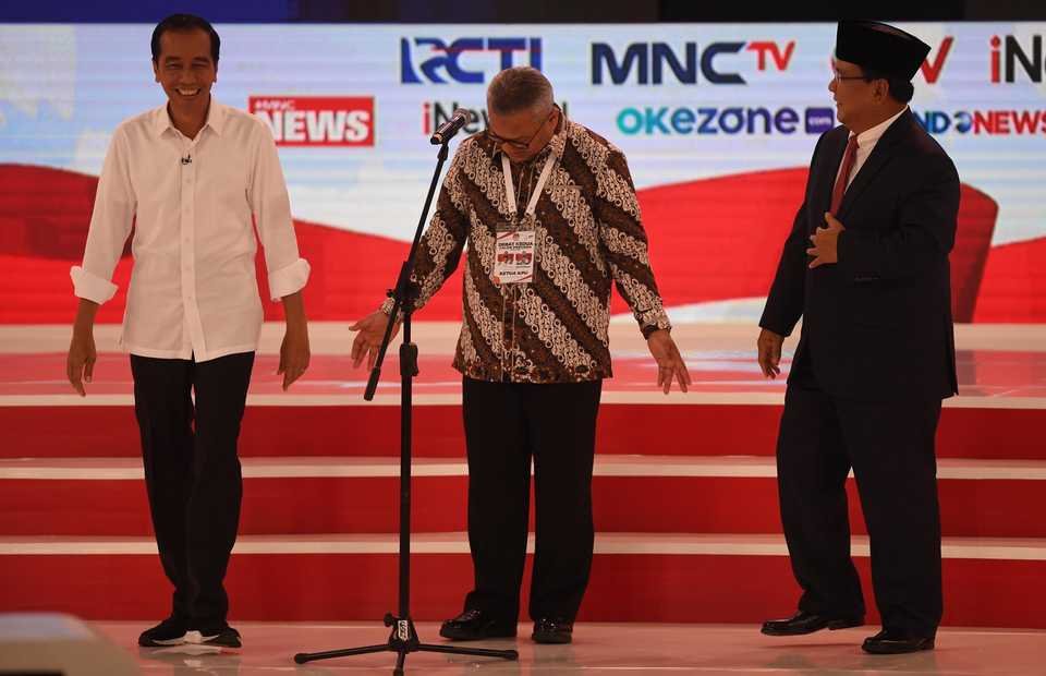 Capres nomor urut 01 Joko Widodo (kiri) dan Capres nomor urut 02 Prabowo Subianto (kanan) bersiap memulai debat capres 2019 disaksikan Ketua KPU Arief Budiman (tengah) di Hotel Sultan, Jakarta, Minggu (17/2/2019).