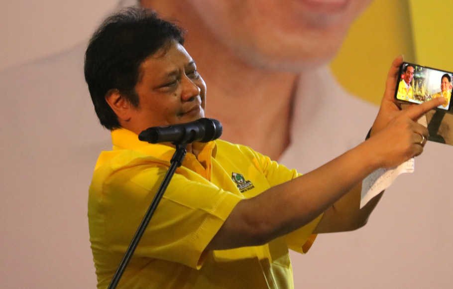 Ketua Umum Partai Golkar Airlangga Hartarto menunjukkan aplikasi berbasis android untuk melakukan swafoto dengan Capres 01 Joko Widodo  saat Kampanye Akbar Partai Golkar di Surabaya, Jawa Timur, Minggu (7/4/2019).