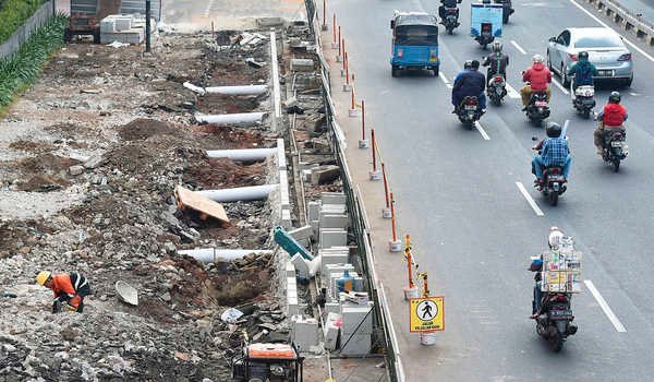 Sejumlah pengendara kendaraan bermotor melaju di samping proyek revitalisasi trotoar di Jalan Salemba, Jakarta Pusat, Senin (29/7/2019).