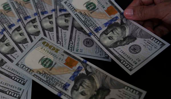 Petugas melayani penukaran uang dolar Amerika di salah satu gerai penukaran valuta asing, Jakarta,