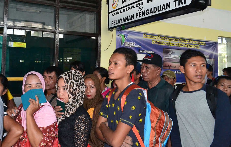 Calon tenaga kerja Indonesia (TKI) tujuan Negeri Sabah, Malaysia mengantre di depan loket Imigrasi Pelabuhan Internasional Tunon Taka Kabupaten Nunukan, Kalimantan Utara, Sabtu (5/9).