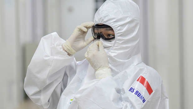 Seorang dokter membetulkan posisi kacamata pelindung saat berada di salah satu ruang modular di Rumah Sakit Pertamina Jaya, Cempaka Putih, Jakarta, Senin (6/4/2020).