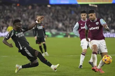 Pemain Arsenal Bukayo Saka (kiri) melepaskan tembakan saat melawan West Ham di Stadion Olimpiade, London, Sabtu, 30 November 2024. (AP/Dave Shopland)