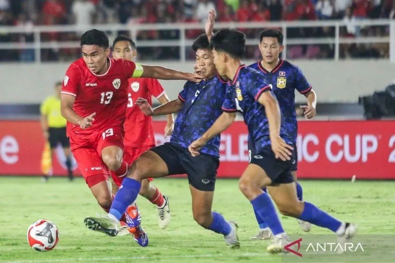Pesepak bola Timnas Laos Phetdavanh Somsanid (ketiga kanan), Anantaza Siphongphan (kedua kanan) dan Phoutthasay Khochalern (kanan) berusaha merebut bola dari pesepak bola Timnas Indonesia M Ferarri (kiri) saat pertandingan Grup B ASEAN Cup 2024 di Stadion Manahan, Solo, Jawa Tengah, Kamis (12/12/2024). ANTARA FOTO/Mohammad Ayudha