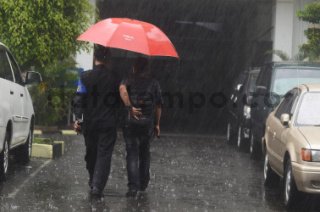 Dua orang sedang gunakan payumg saat hujan.Istimewa